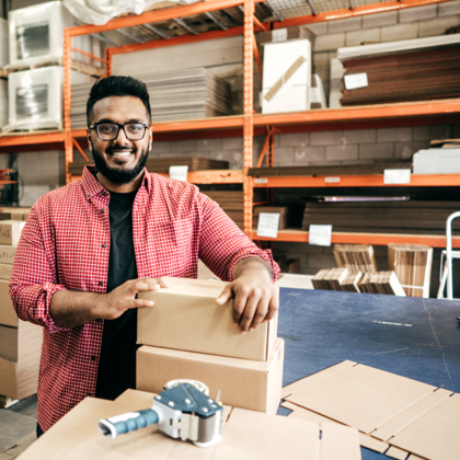 A person holding a parcel in a warehouse